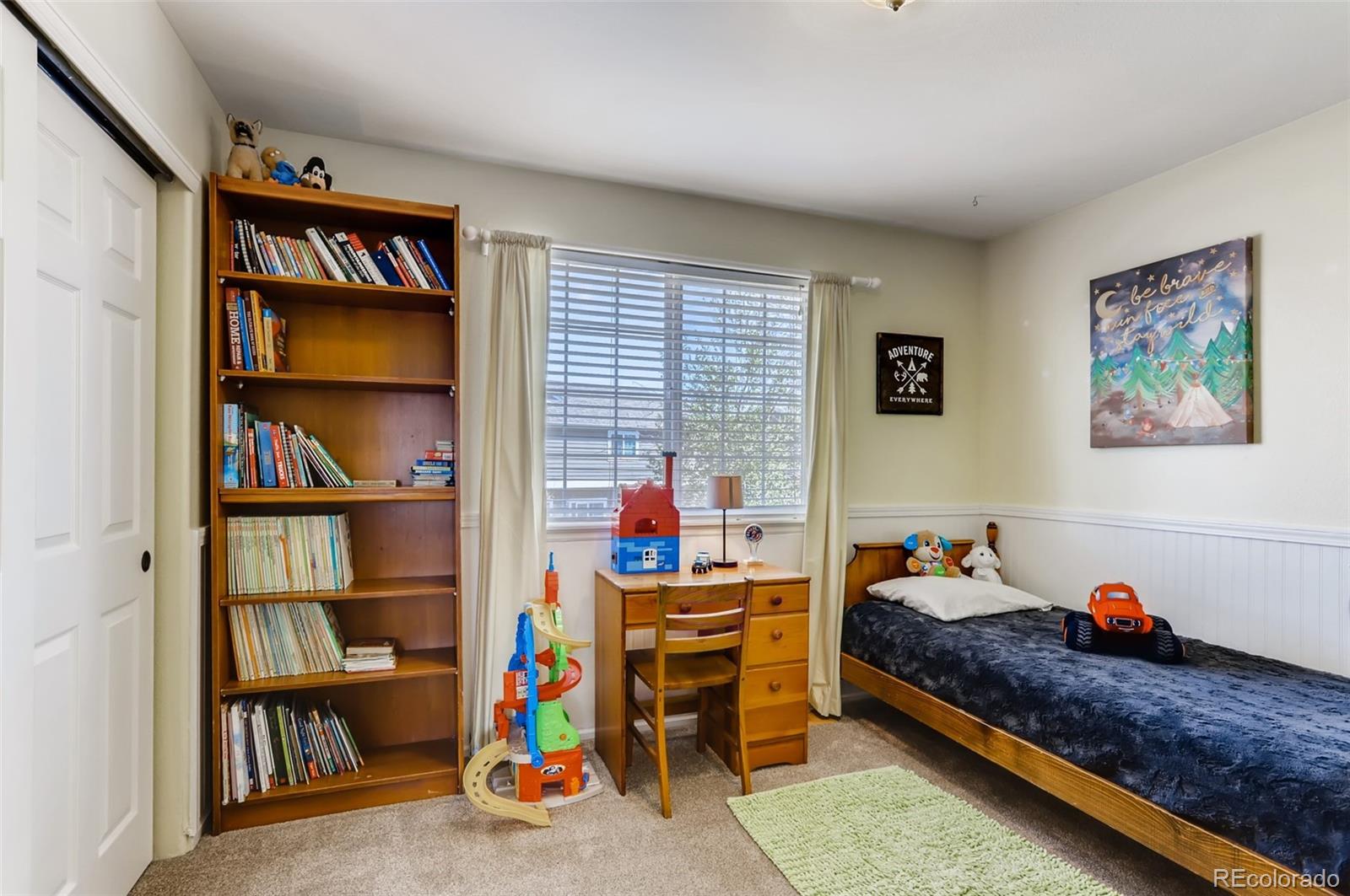 1091 Riddlewood Road Highlands Ranch, CO 80129 - Photo 19 of 26 a bed room with a bed and a book shelf
