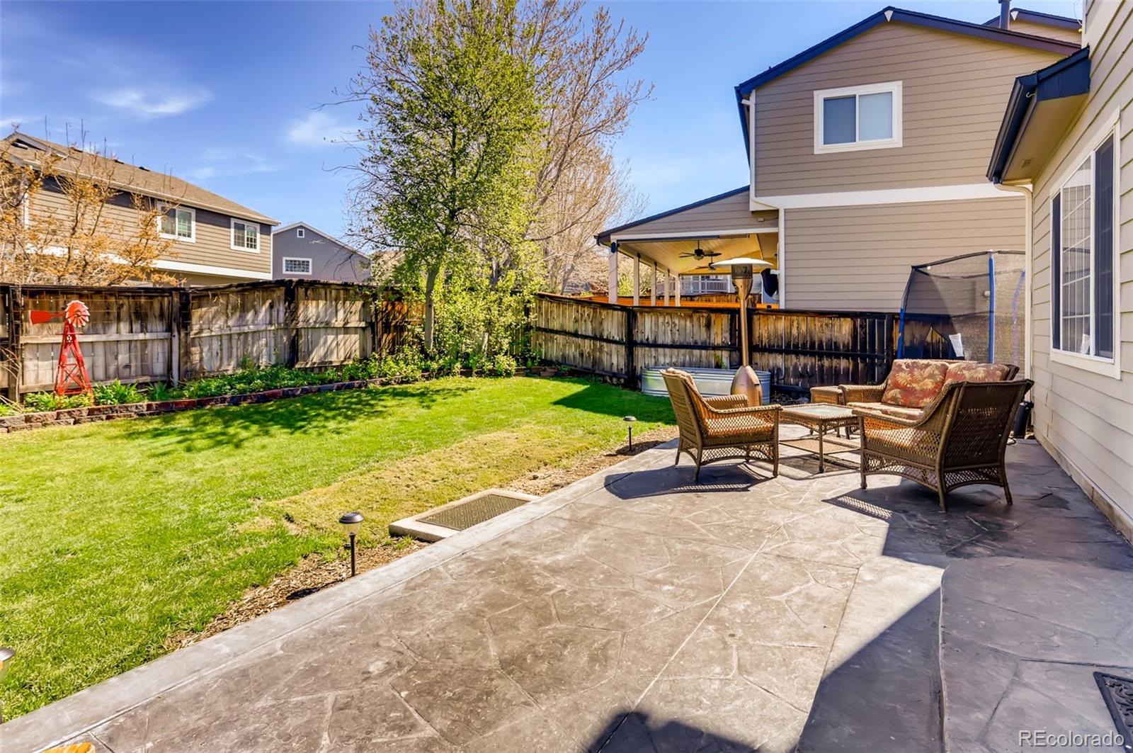1091 Riddlewood Road Highlands Ranch, CO 80129 - Photo 21 of 26 a view of a patio with table and chairs near a yard