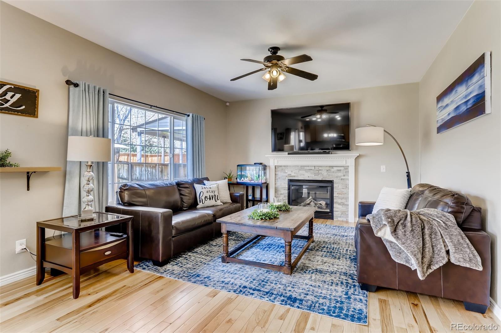 1091 Riddlewood Road Highlands Ranch, CO 80129 - Photo 5 of 26 a living room with furniture a flat screen tv and a fireplace