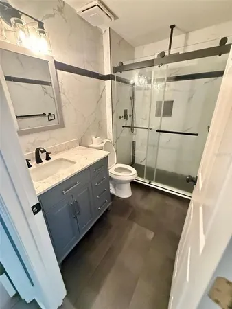 a bathroom with a sink a toilet and shower
