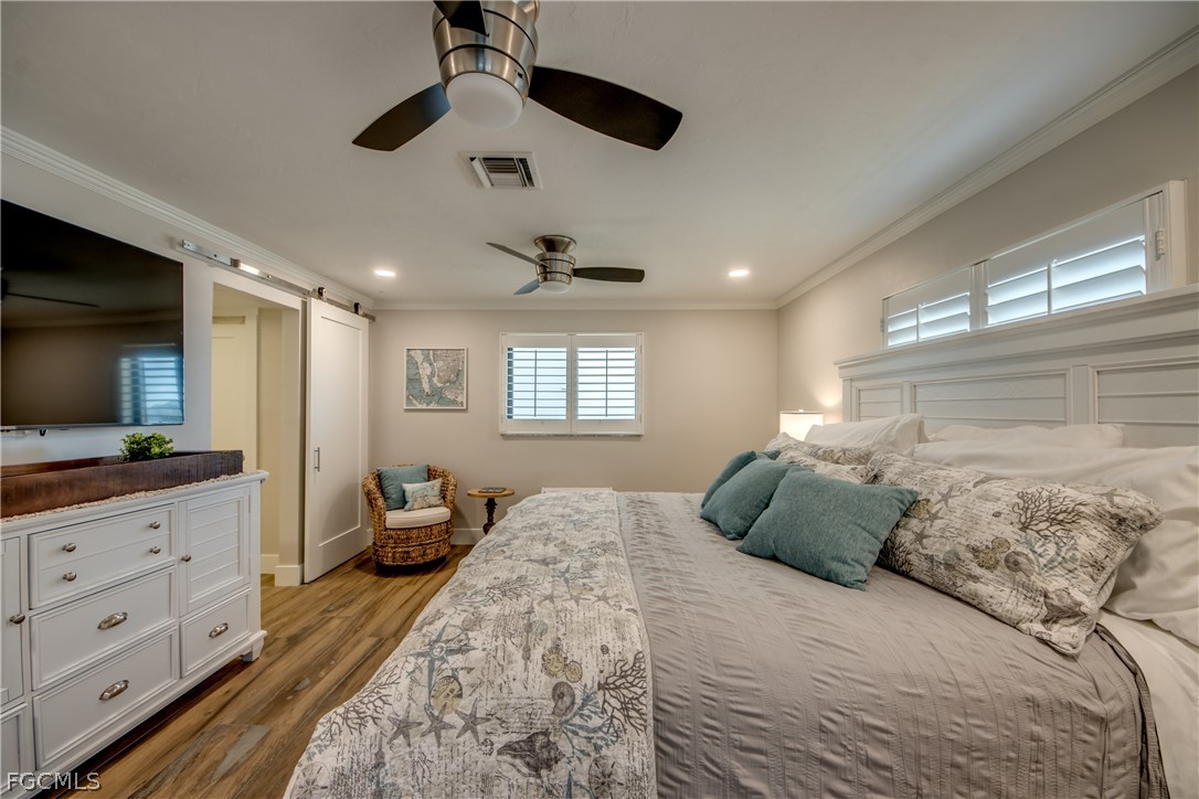 11599 Island Avenue Matlacha, FL 33993 - Photo 17 of 38 a bedroom with a large bed and a flat tv screen on dresser