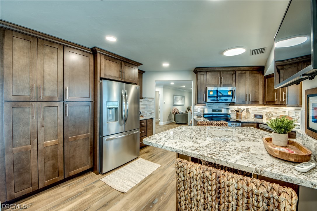 11599 Island Avenue Matlacha, FL 33993 - Photo 10 of 38 a kitchen with stainless steel appliances granite countertop a refrigerator a stove and a sink