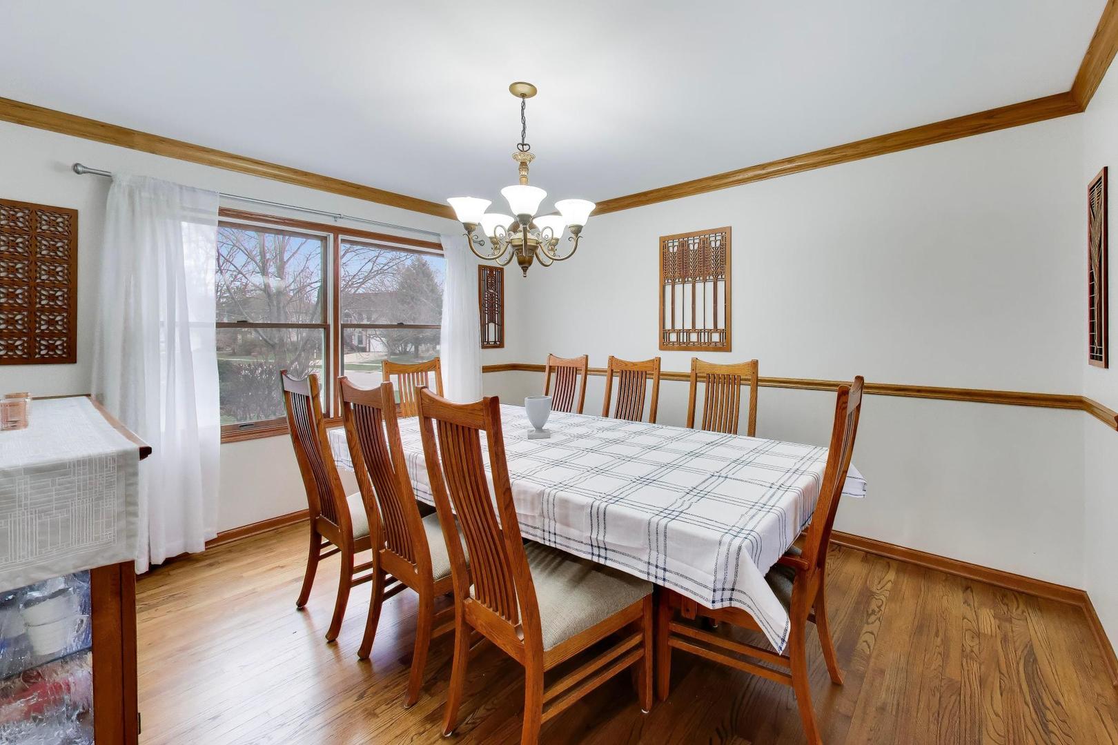 873 Hampton Drive Carol Stream, IL 60188 - Photo 11 of 43 a dining room with furniture a chandelier and wooden floor