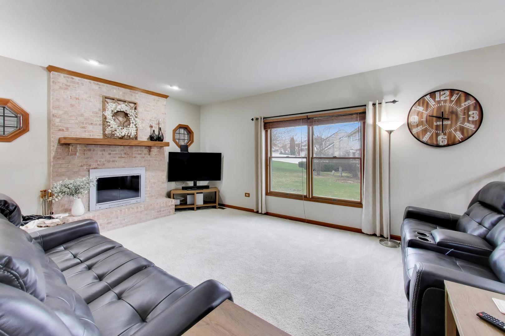 873 Hampton Drive Carol Stream, IL 60188 - Photo 17 of 43 a living room with furniture a fireplace and a flat screen tv