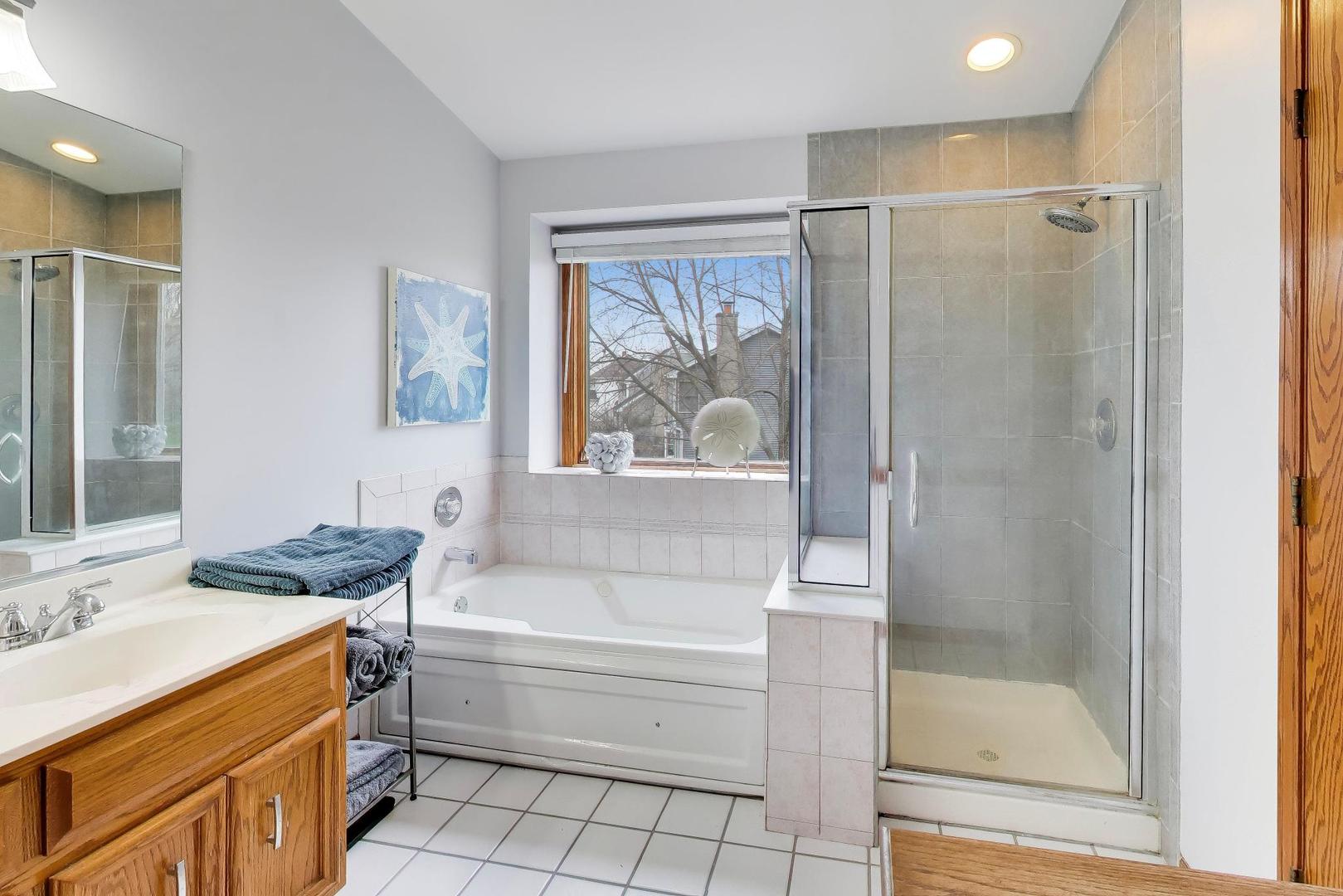 873 Hampton Drive Carol Stream, IL 60188 - Photo 26 of 43 a bathroom with a granite countertop bathtub a shower and a sink
