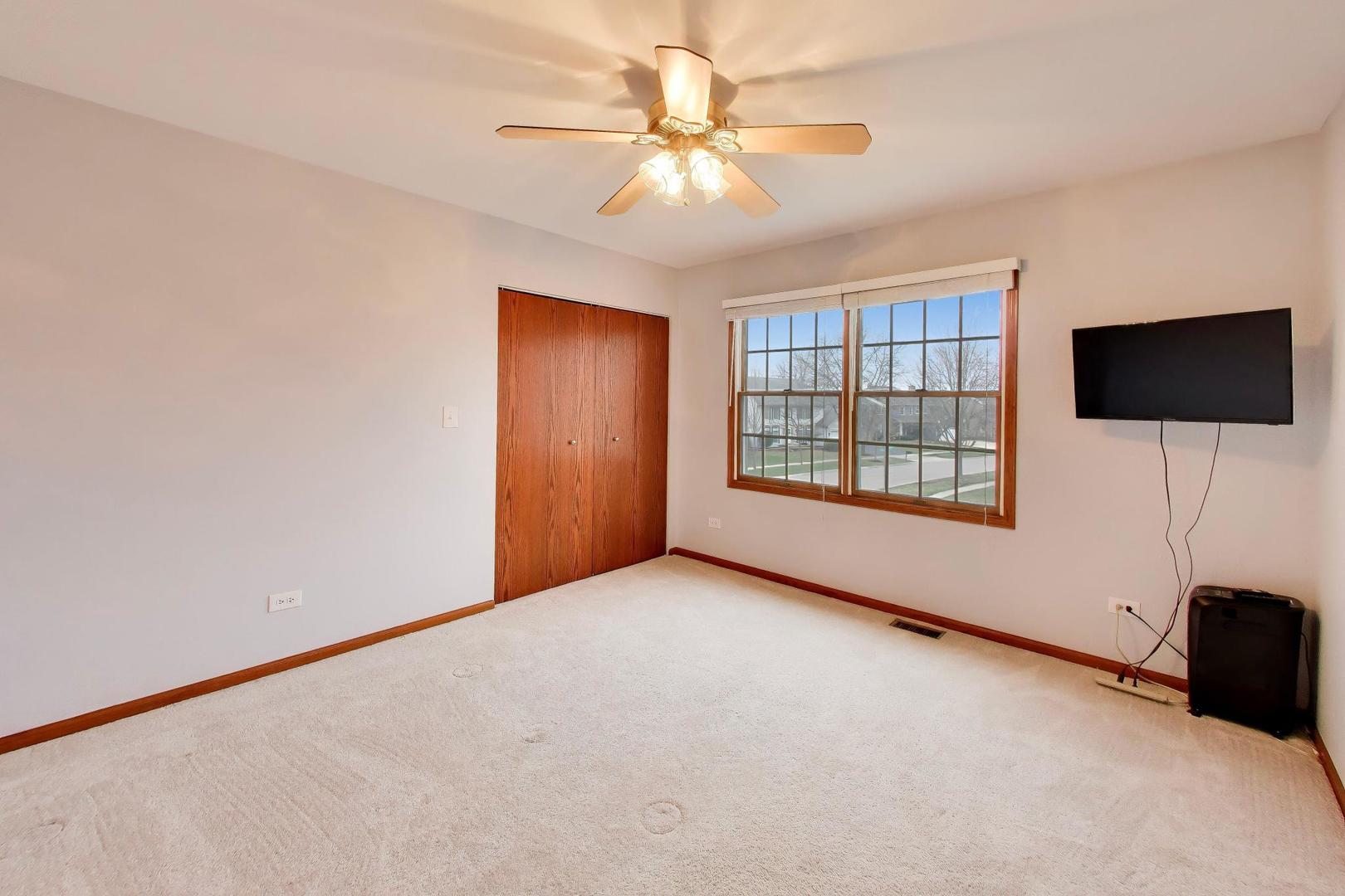873 Hampton Drive Carol Stream, IL 60188 - Photo 29 of 43 an empty room with windows and a ceiling fan