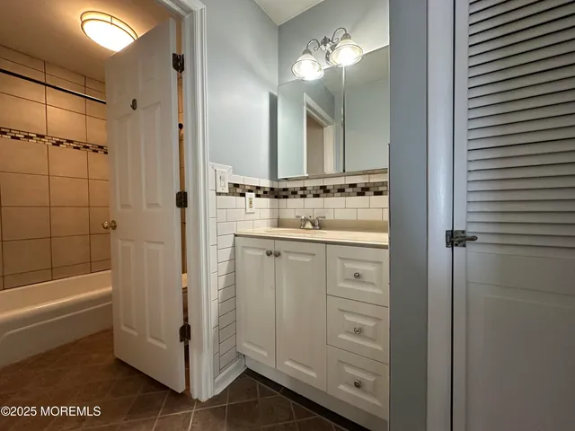 a bathroom with a shower sink and mirror