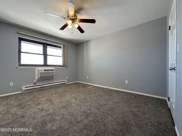 an empty room with windows and ceiling fan