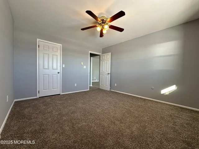 an empty room with closet and fan