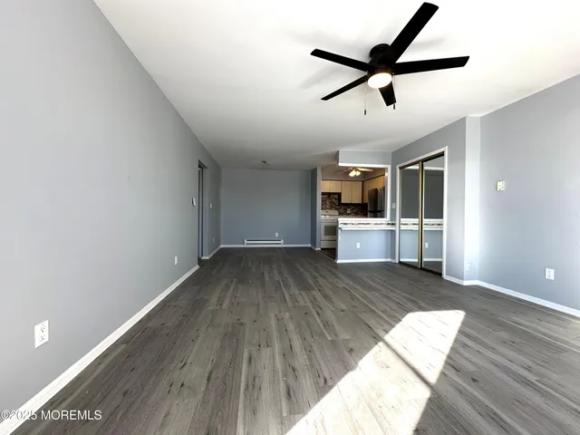 a view of a livingroom with wooden floor and a ceiling fan