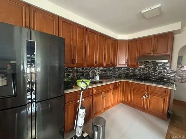 a kitchen with stainless steel appliances granite countertop a refrigerator a sink and a stove