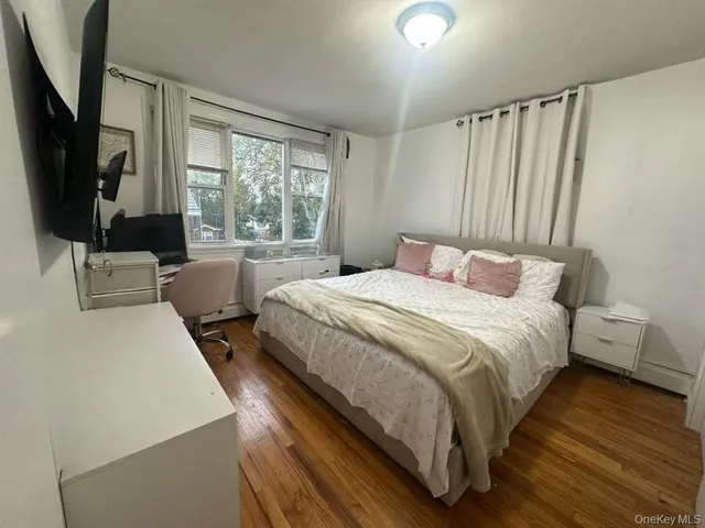 a bedroom with a bed a large window and flat screen tv