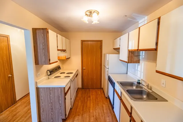 a kitchen with a sink a stove and a refrigerator
