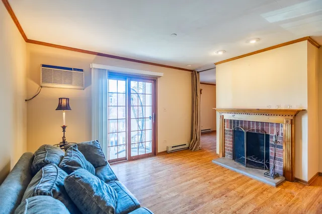 a living room with furniture a fireplace and a large window