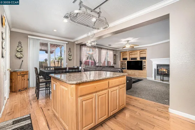 a kitchen with stainless steel appliances granite countertop a sink and chairs