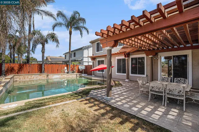 a backyard of a house with barbeque oven table and chairs