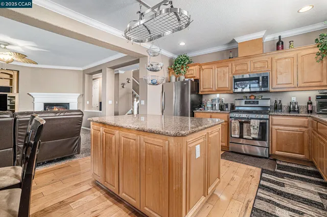 a kitchen with stainless steel appliances granite countertop a sink a stove and a refrigerator