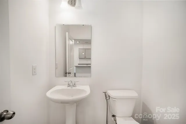 a bathroom with a granite countertop sink a toilet and a mirror