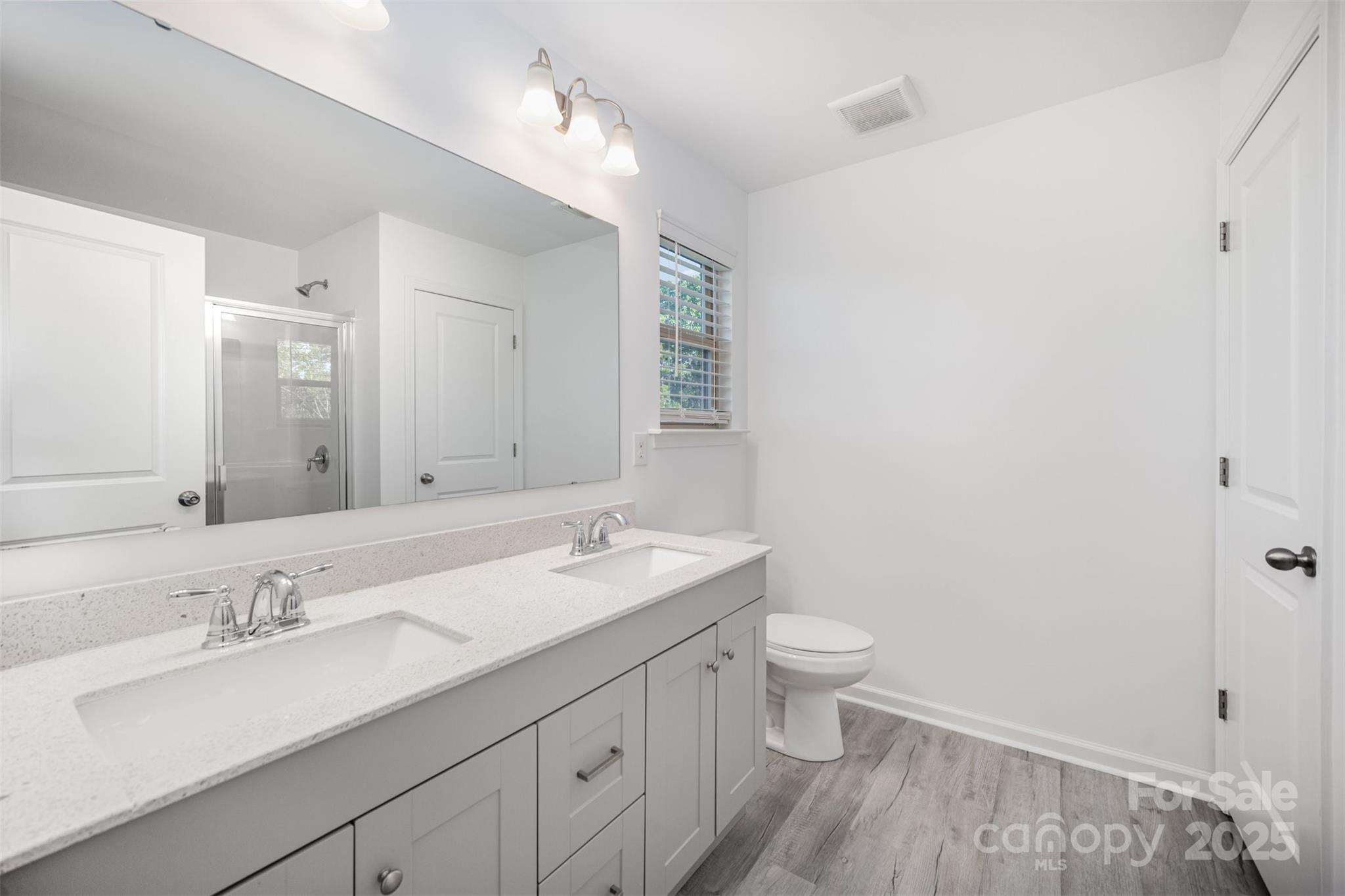 558 Dulaney Drive Tega Cay, SC 29708 - Photo 21 of 30 a bathroom with a granite countertop sink a toilet and a mirror