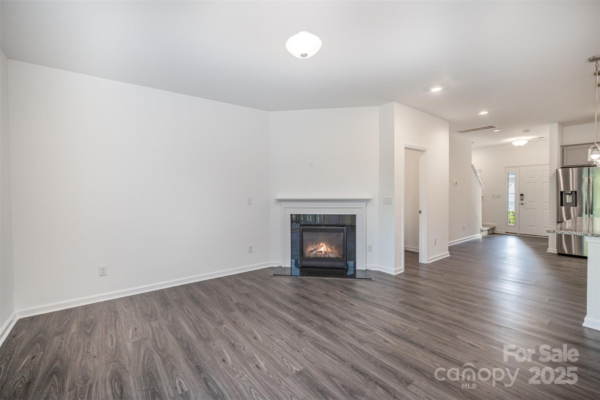 558 Dulaney Drive Tega Cay, SC 29708 - Photo 6 of 30 a view of a livingroom with wooden floor and a fireplace