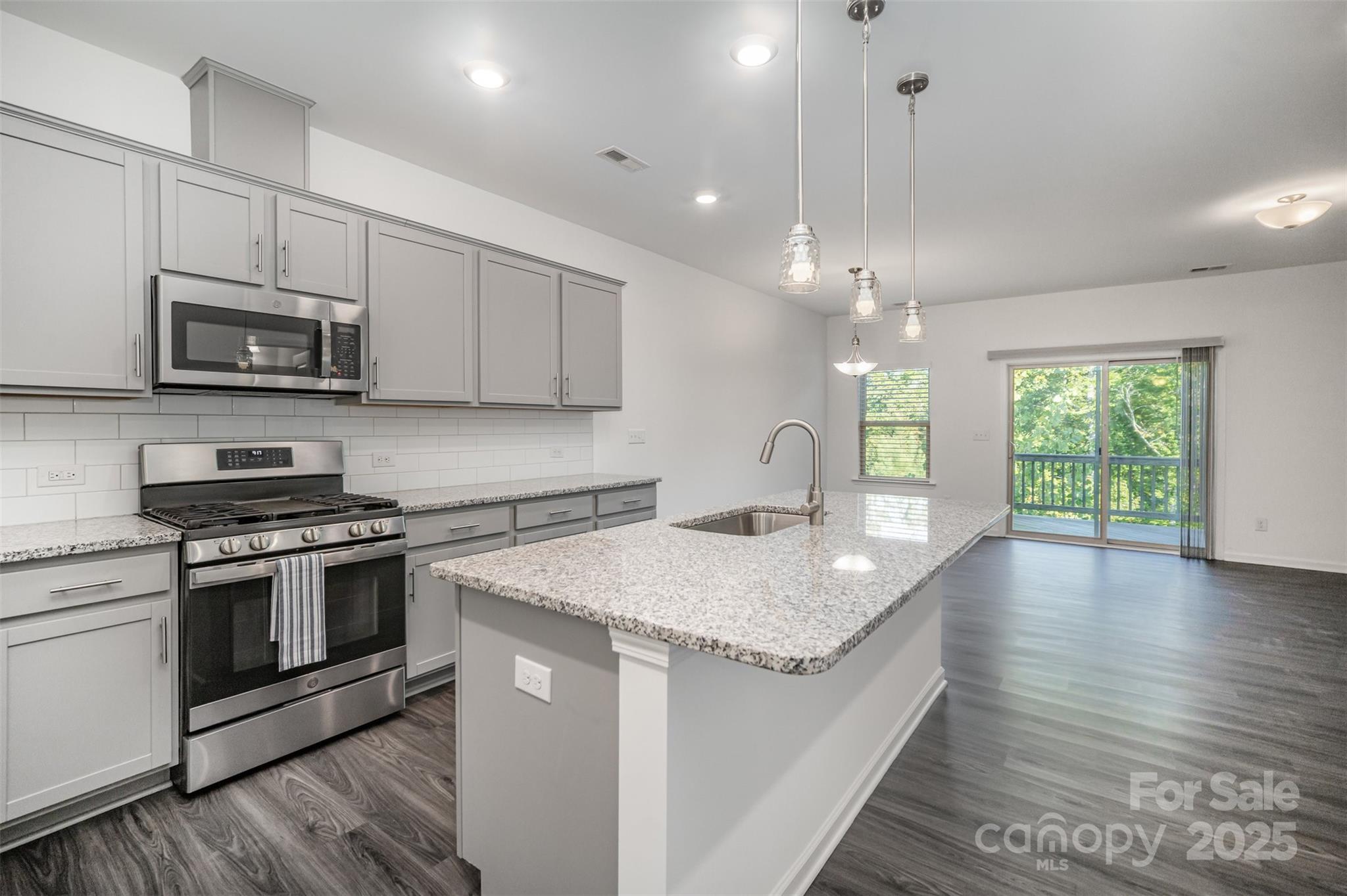 558 Dulaney Drive Tega Cay, SC 29708 - Photo 9 of 30 a kitchen with granite countertop a sink a counter top space appliances and cabinets