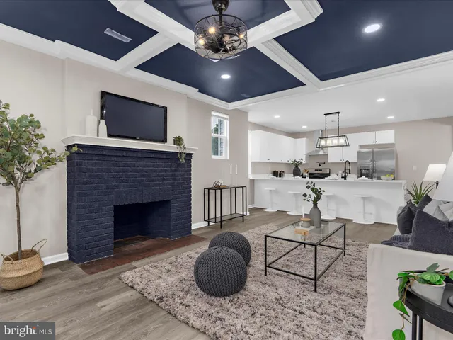 a living room with furniture a flat screen tv and kitchen view