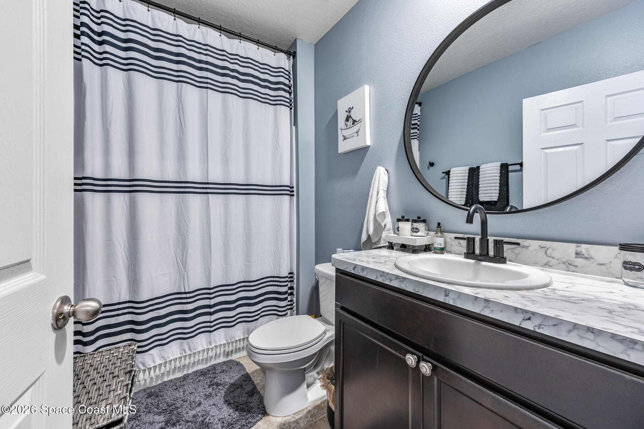 3054 Toulon Road Southeast Palm Bay, FL 32909 - Photo 22 of 30 a bathroom with a sink a toilet and a mirror