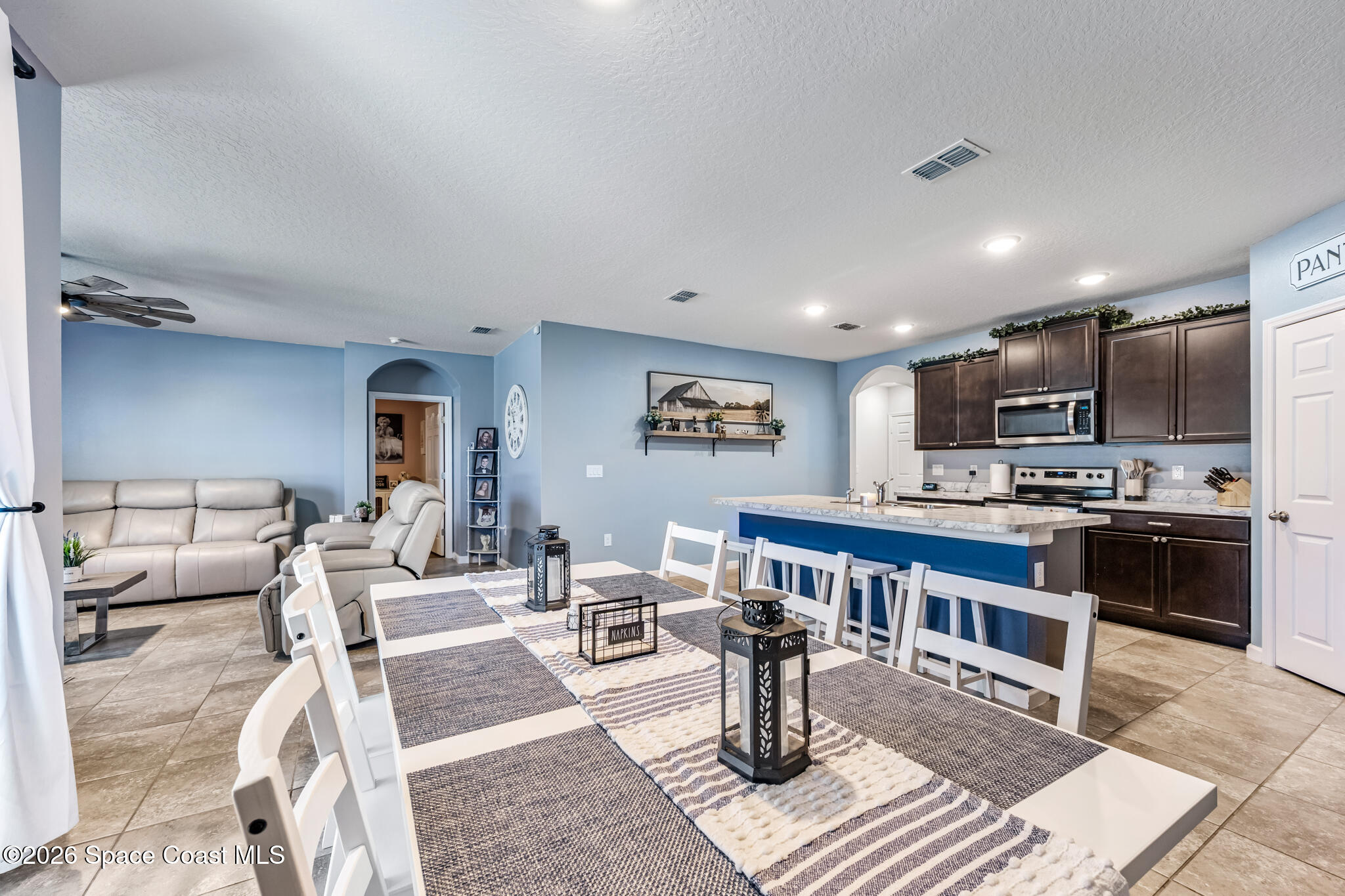 3054 Toulon Road Southeast Palm Bay, FL 32909 - Photo 10 of 30 a living room with furniture a kitchen view and a wooden floor