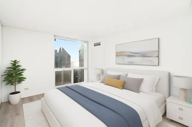 a bedroom with a large bed and a potted plant