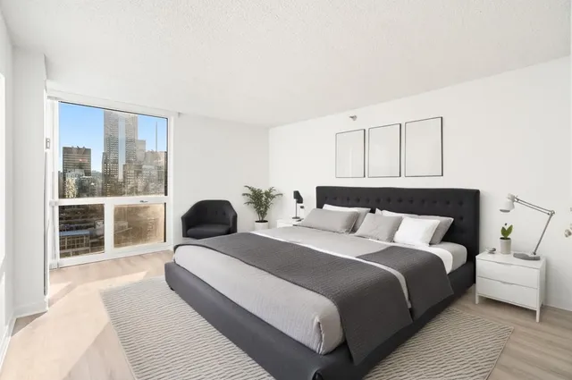 a bedroom with a large bed and a large window