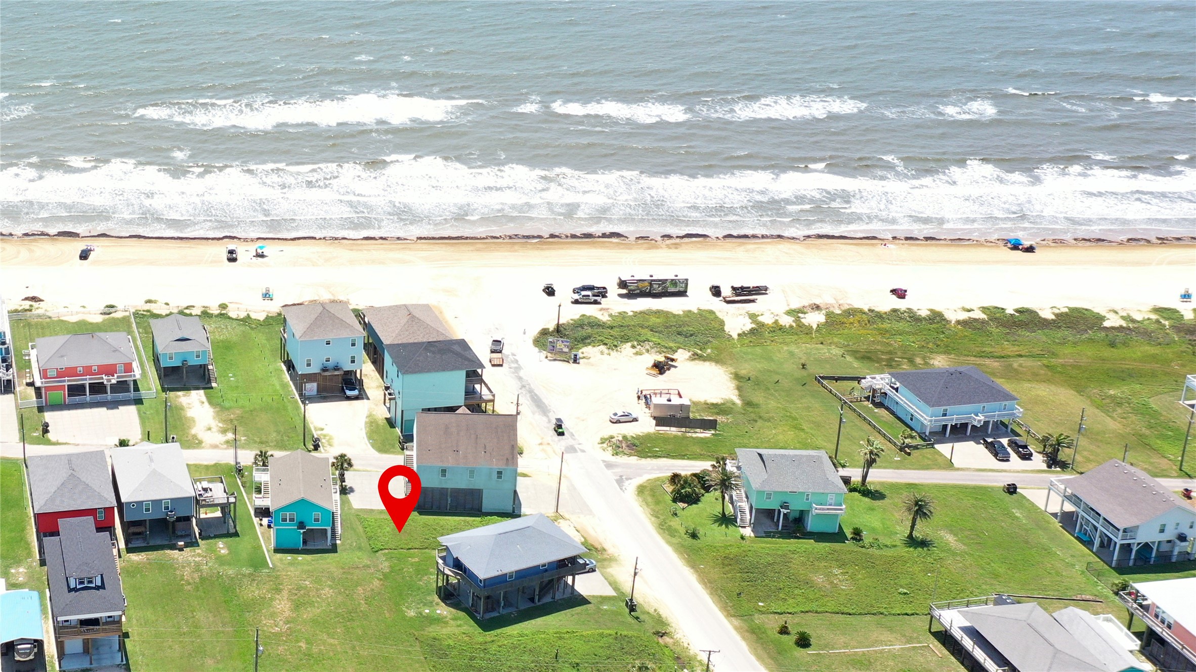 0 Crystal Beach Road Crystal Beach, TX 77650 - Photo 10 of 18 This aerial photo shows a beachfront neighborhood with several colorful houses near the ocean. The property marked is close to the beach, offering easy access and scenic views of the water. Ideal for beachside living.