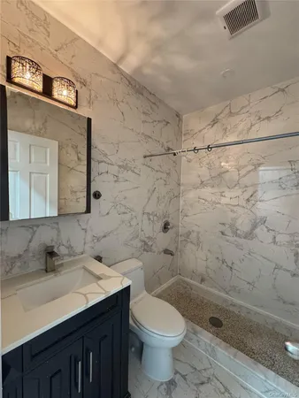 a bathroom with a sink a toilet and shower