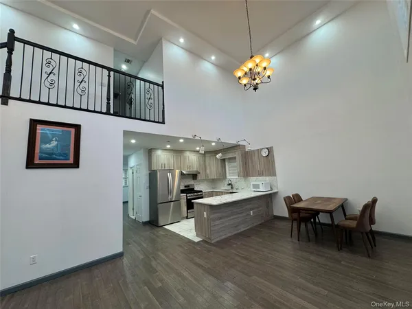 a living room with kitchen island furniture and a chandelier