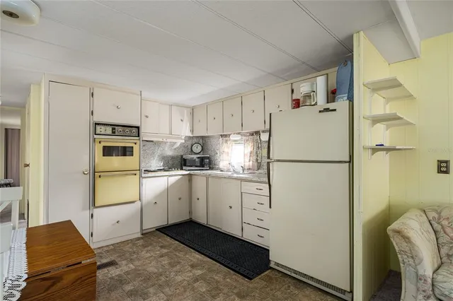 a kitchen with cabinets a refrigerator and a stove