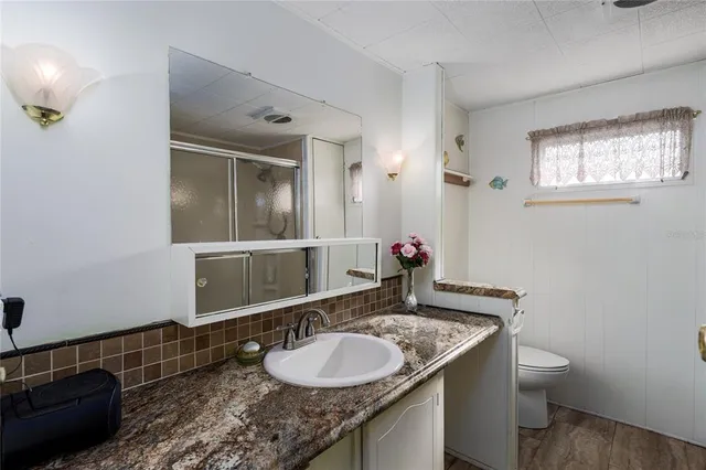 a bathroom with a granite countertop sink and a mirror