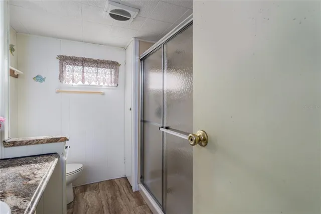 a bathroom with a granite countertop sink toilet and shower