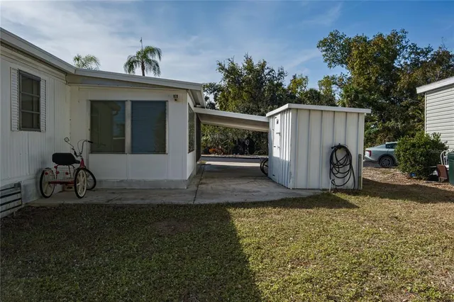 a view of a house with backyard and a tree