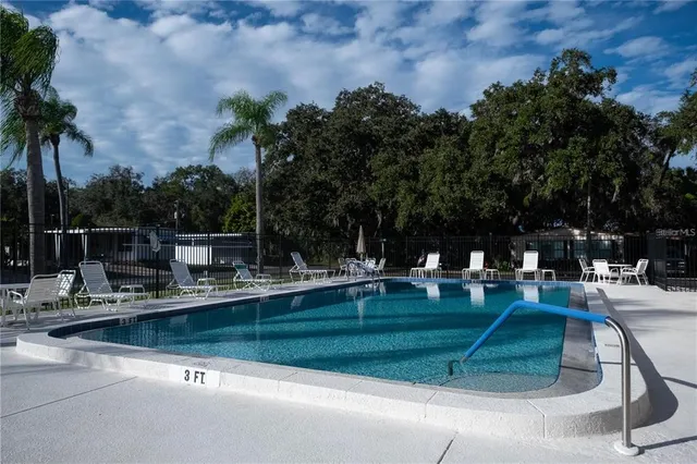 a view of backyard with swimming pool and outdoor seating