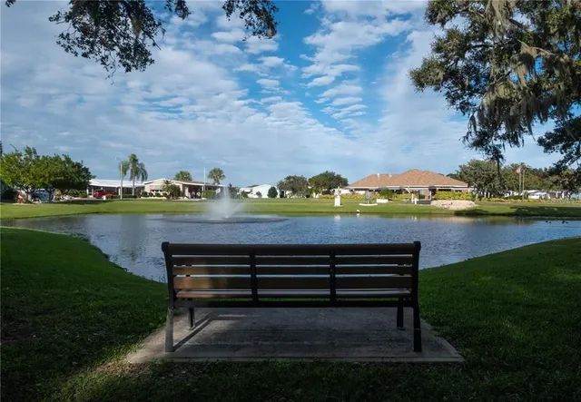 a view of a bench in the garden near a lake