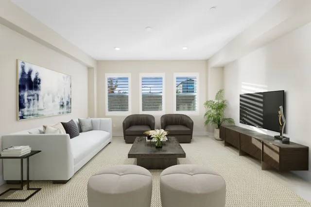 a spacious bedroom with a bed a couch and a large window