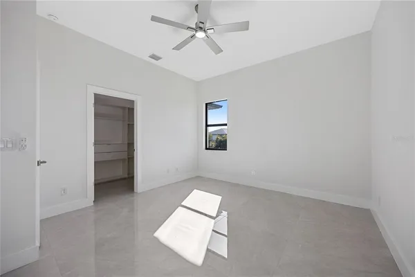 an empty room with a ceiling fan and a window