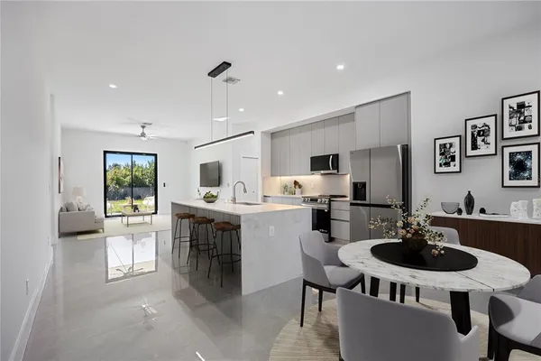 a kitchen with a dining table chairs sink and stove