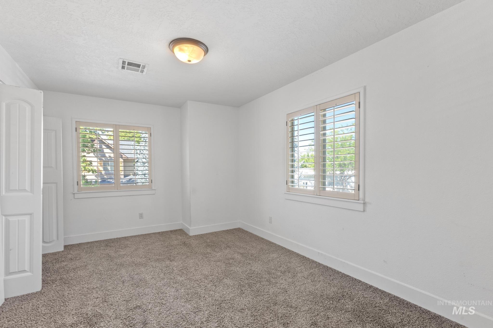 5271 West Morris Hill Road Boise, ID 83706 - Photo 25 of 32 Unfurnished room featuring carpet floors, healthy amount of natural light, and a textured ceiling