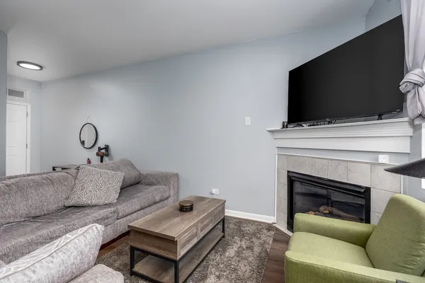 a living room with furniture a flat screen tv and a fireplace