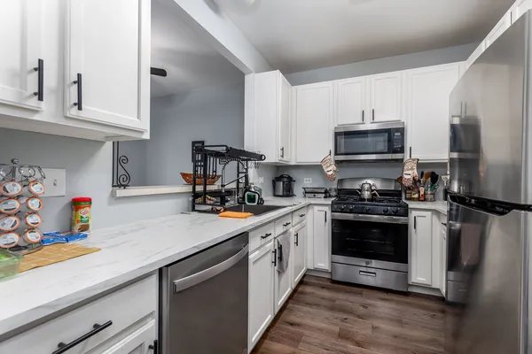 a kitchen with stainless steel appliances a sink a stove and cabinets