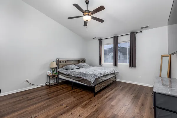 a bedroom with a bed and a table with wooden floor