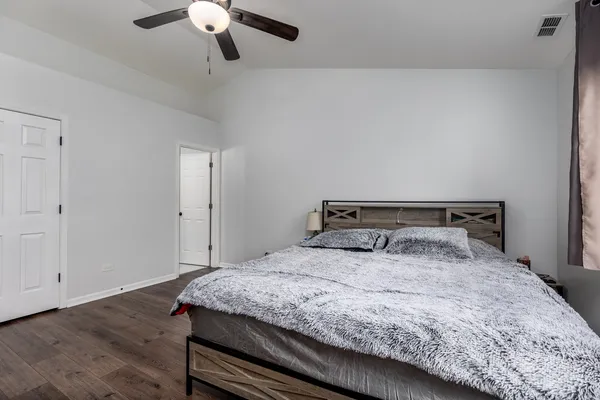 a bedroom with a bed and wooden floor