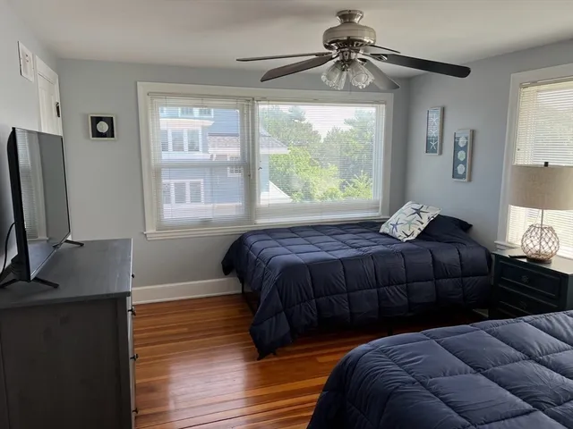 a bedroom with a bed window and a flat screen tv