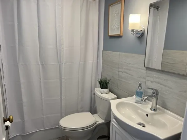 a bathroom with a sink a toilet and shower curtain