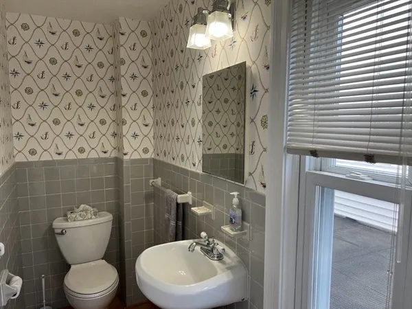 a bathroom with a toilet a sink and mirror